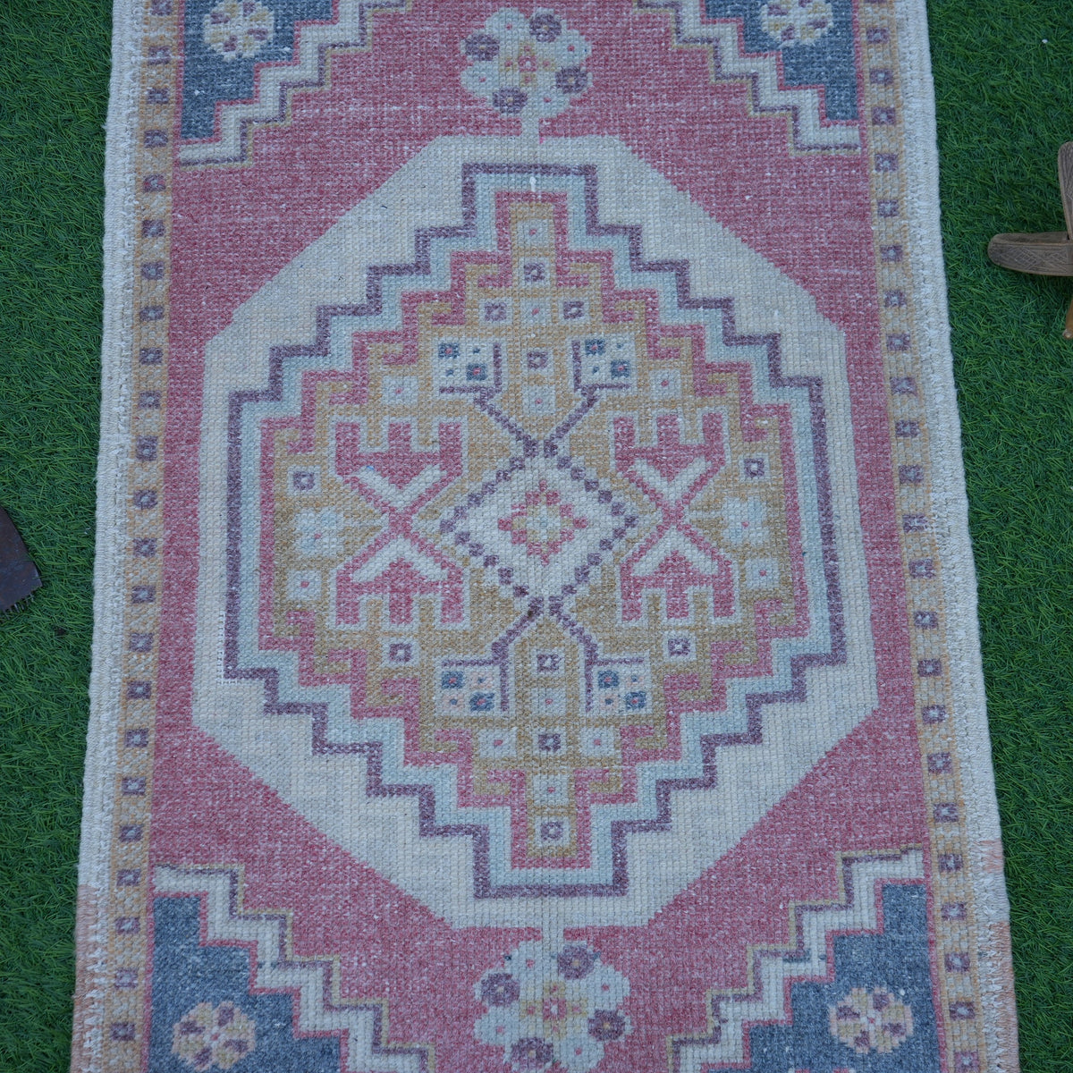 Close-up of the red Turkish mini vintage rug showing traditional details, hand-knotted weave, wool and cotton and low pile.