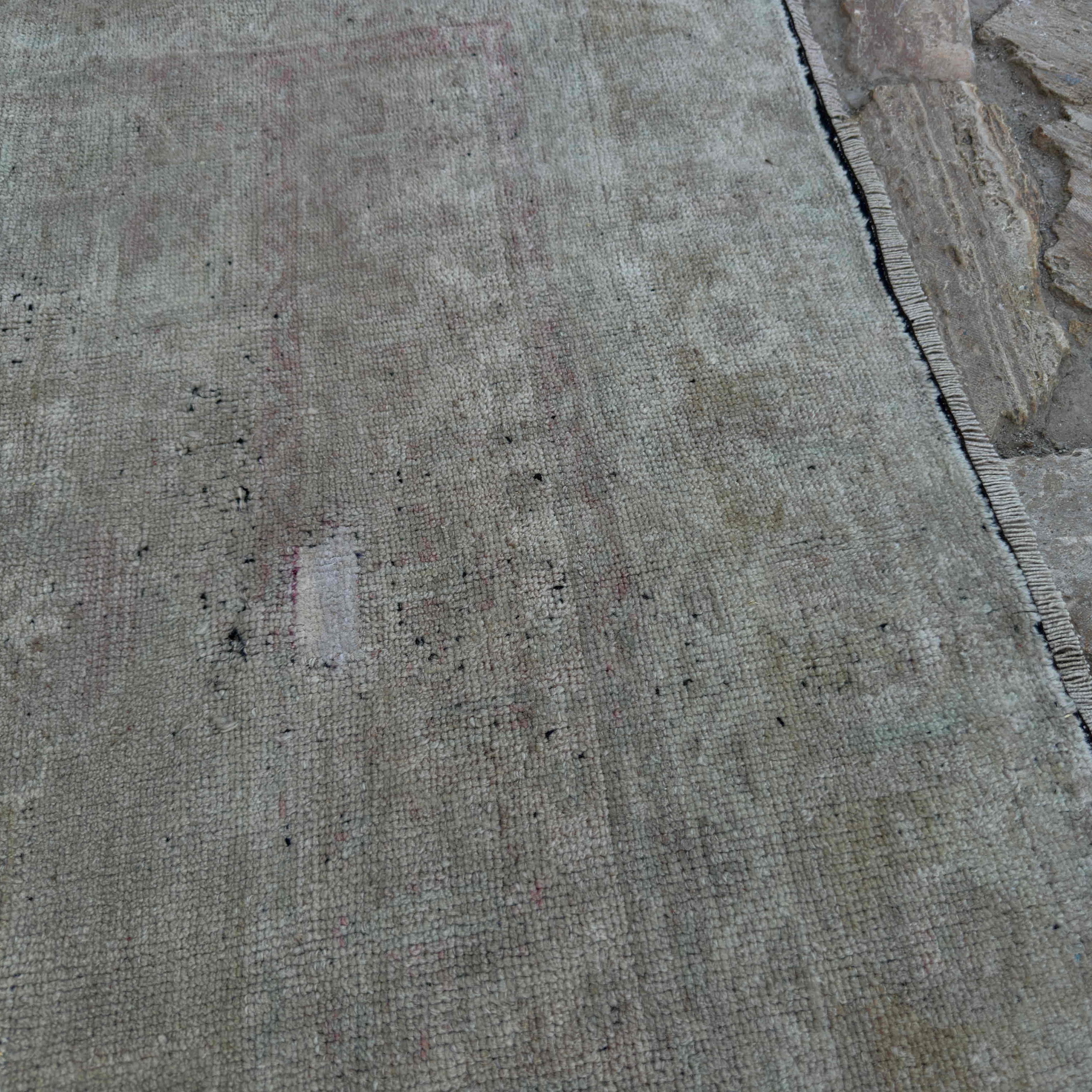 Close-up of the beige Turkish muted vintage rug showing neutral details, hand-knotted weave, wool and cotton and low pile.