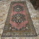 Close-up of the pink Turkish oriental wool rug showing geometric details, hand-knotted weave, wool and cotton and low pile.