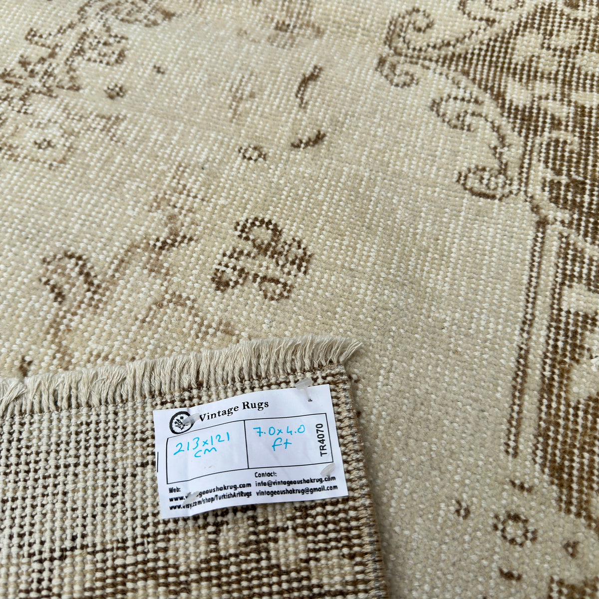 Close-up of the beige Turkish oriental wool rug showing medallion details, hand-knotted weave, wool and cotton and low pile.
