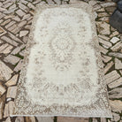 Beige 4' x 7' Turkish oriental wool rug in wool and cotton, shown on the floor.