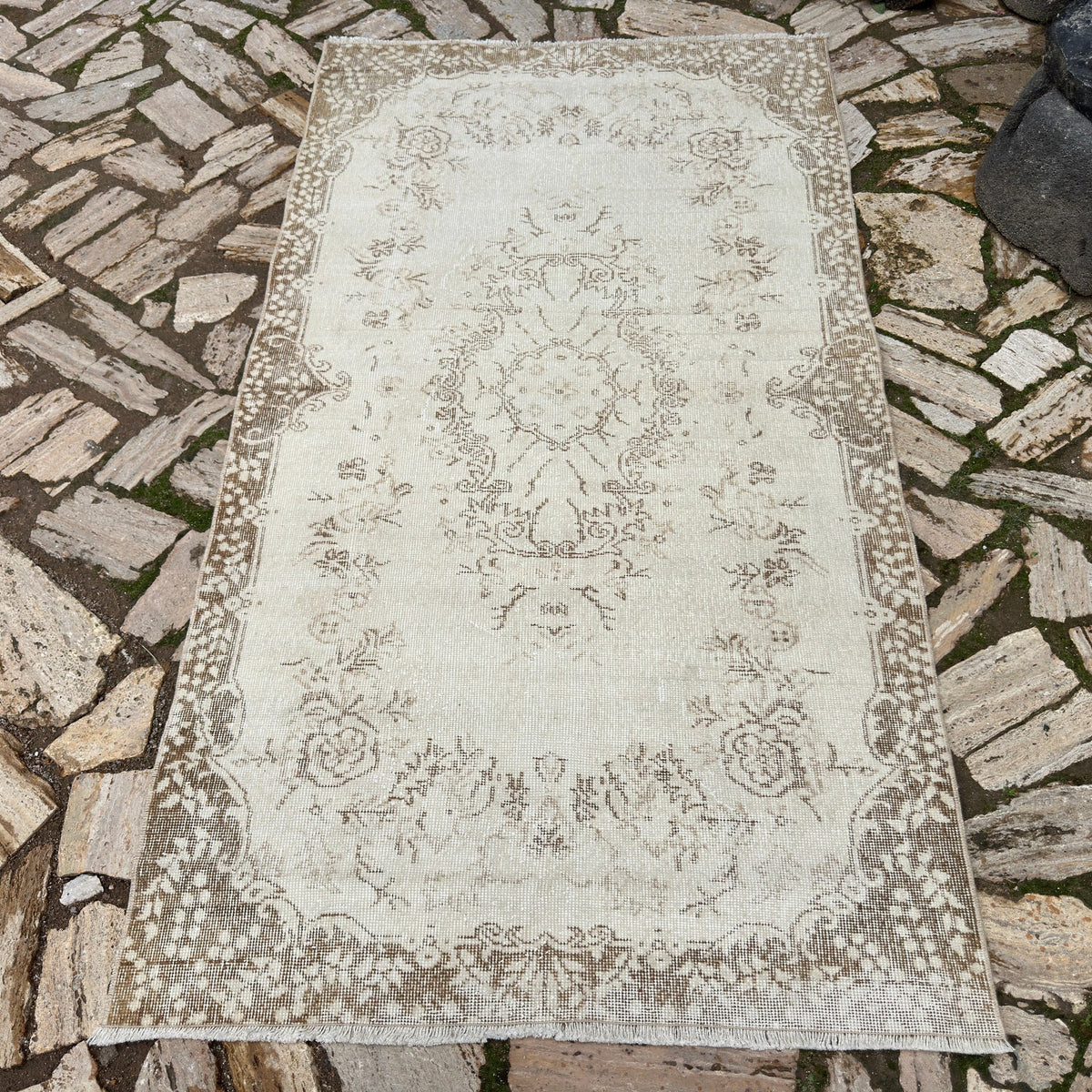 Beige 4' x 7' Turkish oriental wool rug in wool and cotton, shown on the floor.