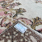 Close-up of the brown Turkish oriental wool rug showing medallion details, hand-knotted weave, wool and cotton and low pile.