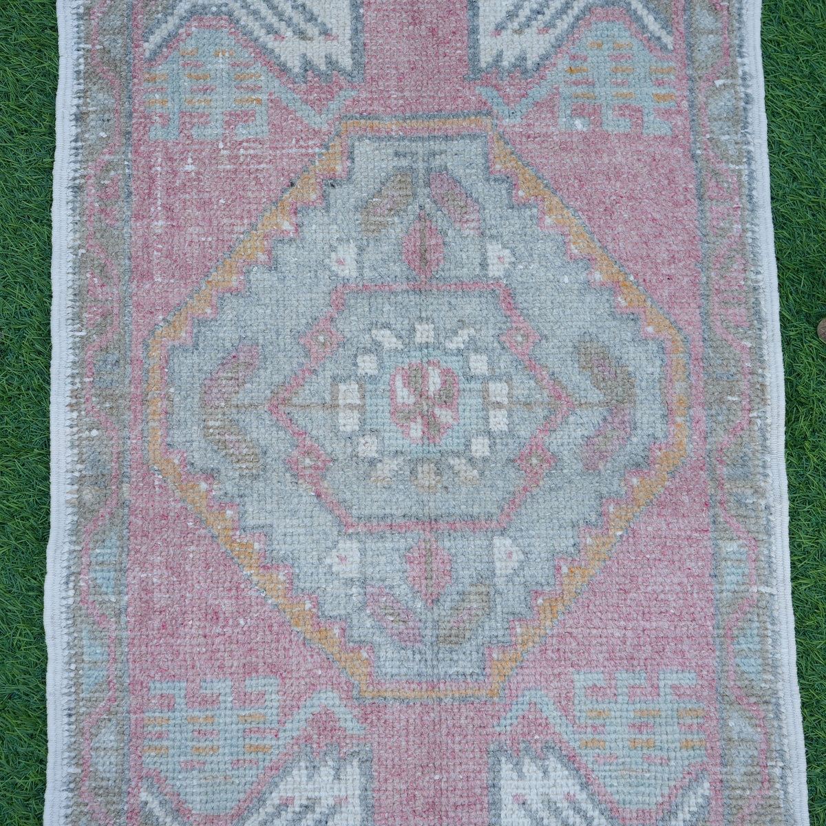 Close-up of the red Turkish oushak mini rug showing traditional details, hand-knotted weave, wool and cotton and low pile.