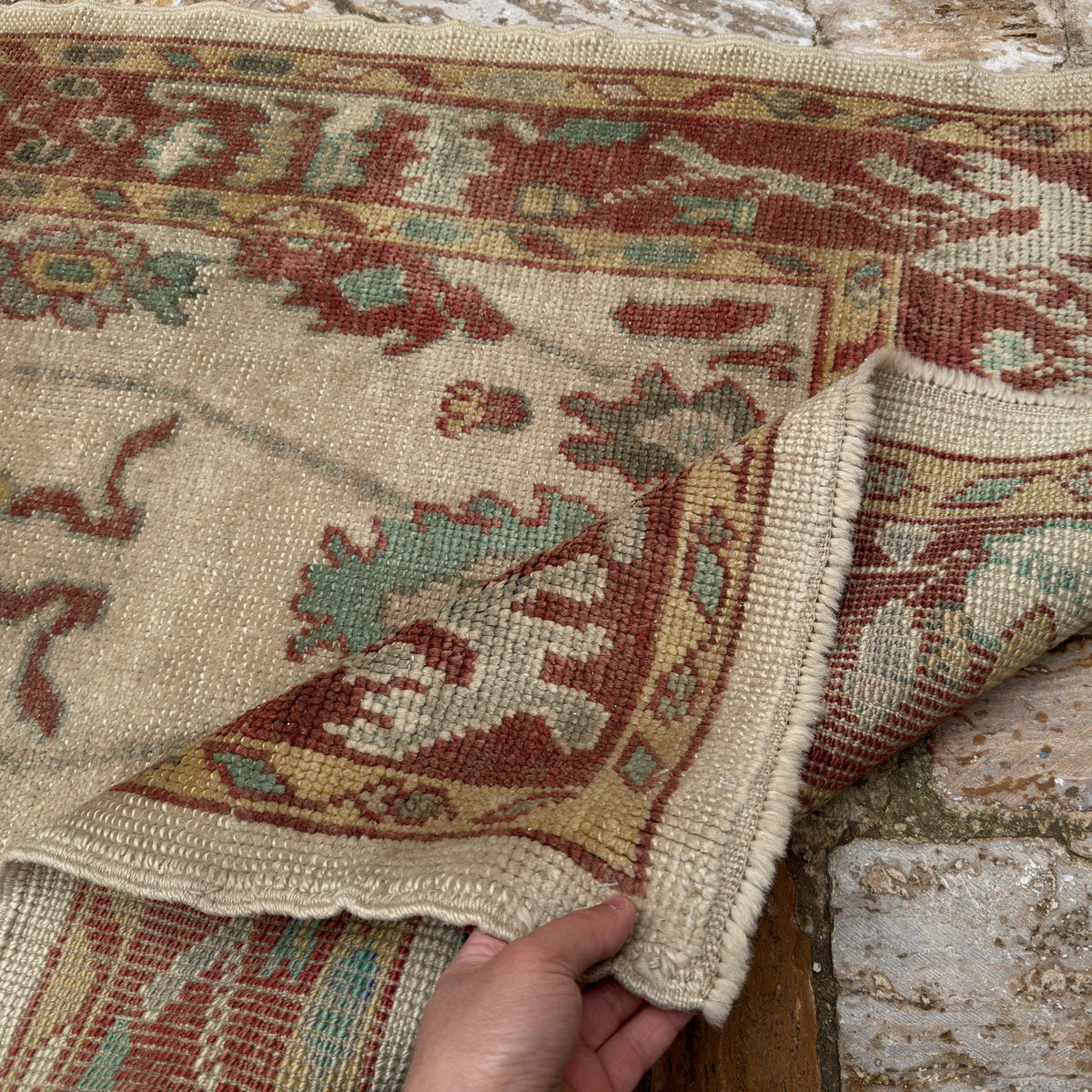 Close-up of the red Turkish oushak runner rug showing oushak details, hand-knotted weave, wool and low pile.