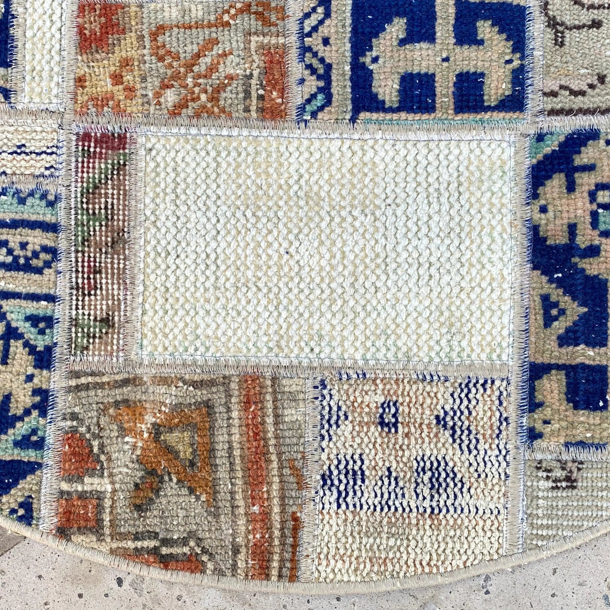 Close-up of the blue Turkish patchwork round rug showing patchwork details, hand-knotted weave, wool and cotton and low pile.