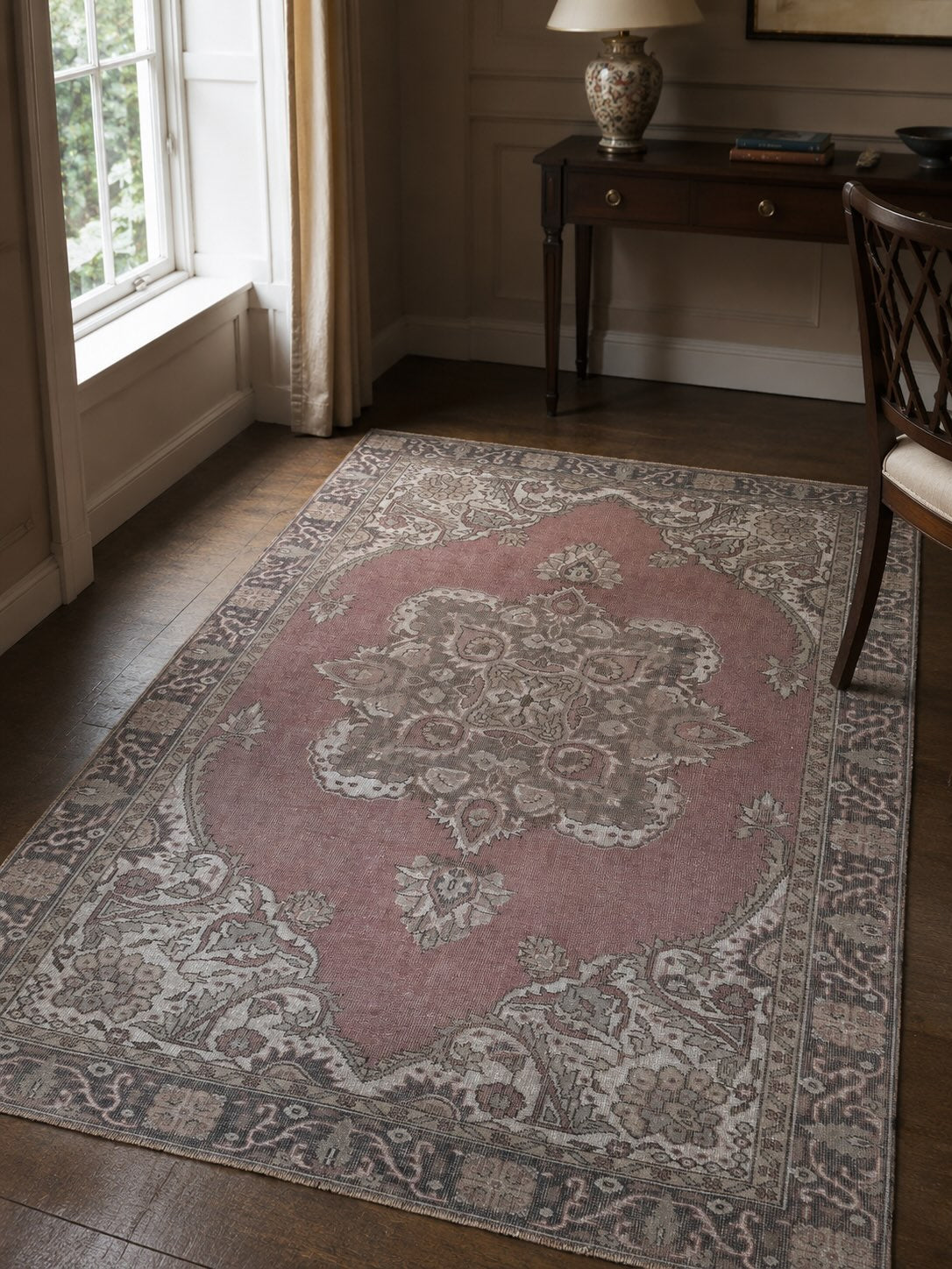 Pale red vintage rug with a formal central medallion, styled in a traditional room to illustrate Persian-inspired rug design
