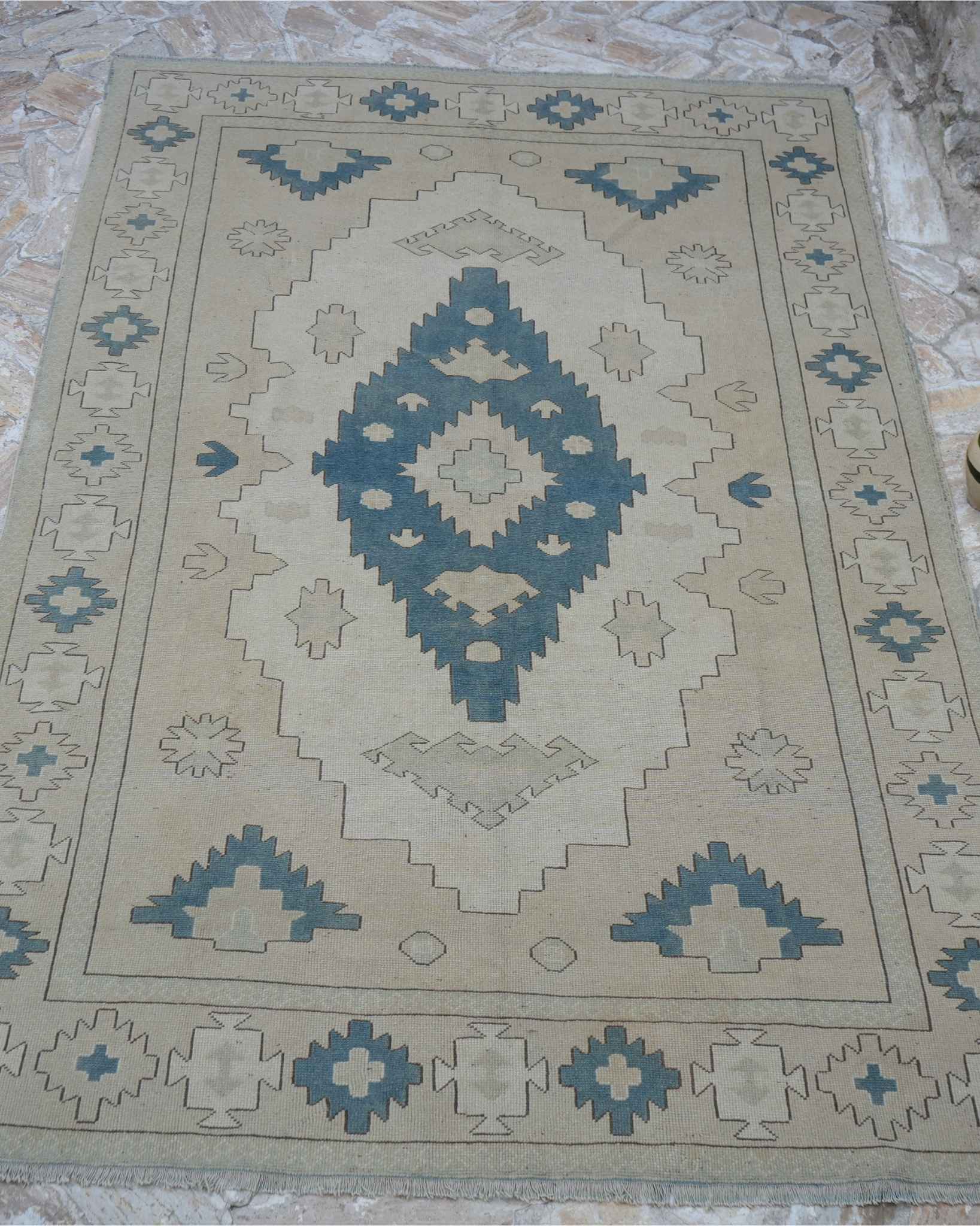 Whole vintage Turkish rug photographed from directly above, showing field, border and overall wear