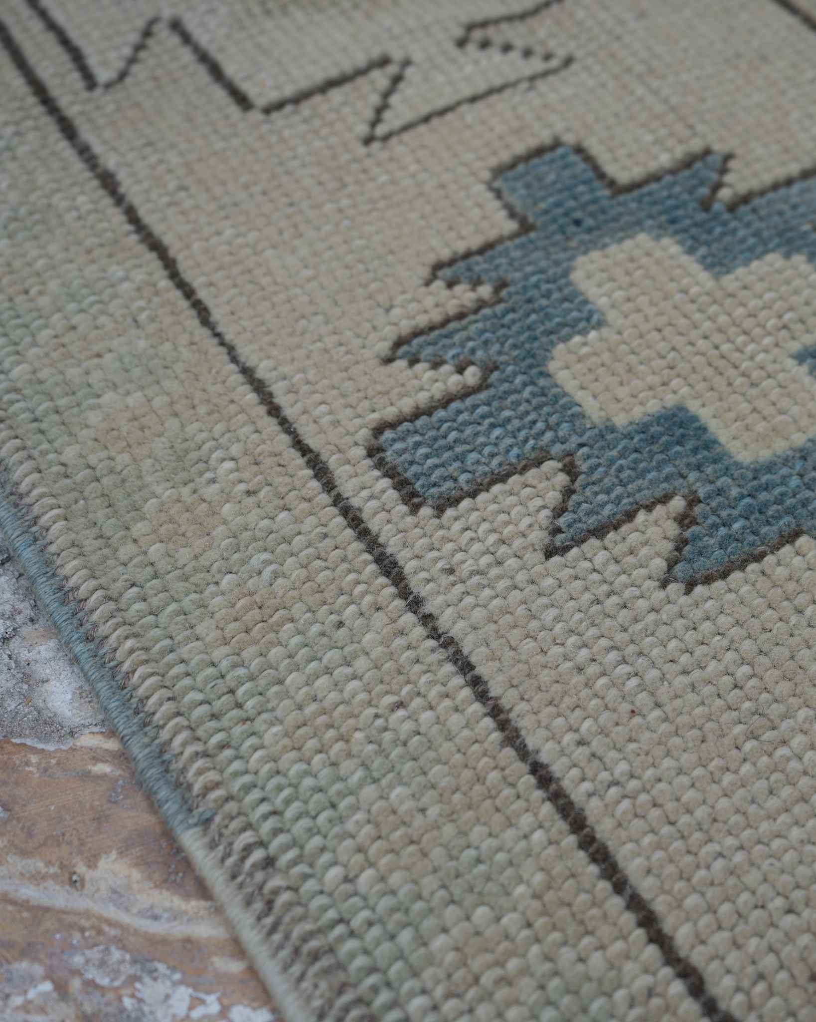 Close-up of hand-knotted wool pile showing individual knots and a subtle abrash colour change
