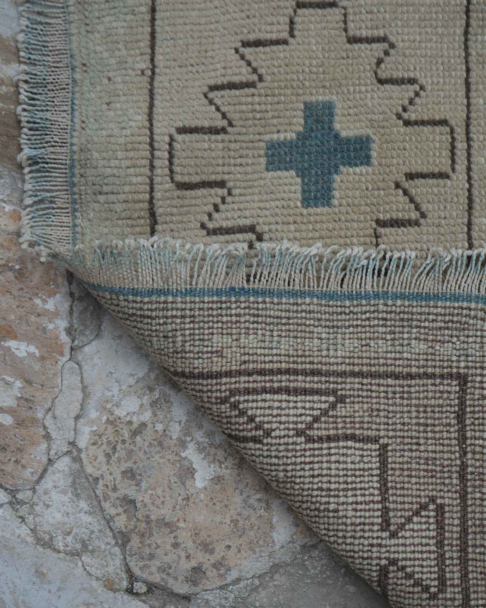 Fringe and selvedge side edge of a hand-knotted rug, showing warp threads and edge finishing