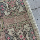 Close-up of the pink Turkish small anatolian rug showing traditional details, hand-knotted weave, wool and cotton and low pile.