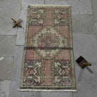 Pink 2' x 3' Turkish small anatolian rug in wool and cotton, shown on the floor.