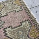 Close-up of the pink Turkish small area rug showing traditional details, hand-knotted weave, wool and cotton and low pile.
