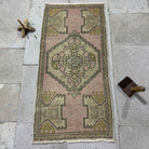 Pink 1' x 3' Turkish small area rug in wool and cotton, shown on the floor.