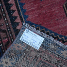 Red 3' x 6' small persian rug from the 1970s with traditional design.