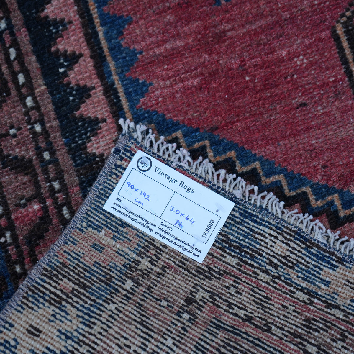 Red 3' x 6' small persian rug from the 1970s with traditional design.