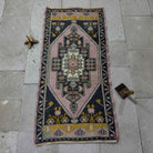 Pink 2' x 4' Turkish small runner rug in wool and cotton, shown on the floor.