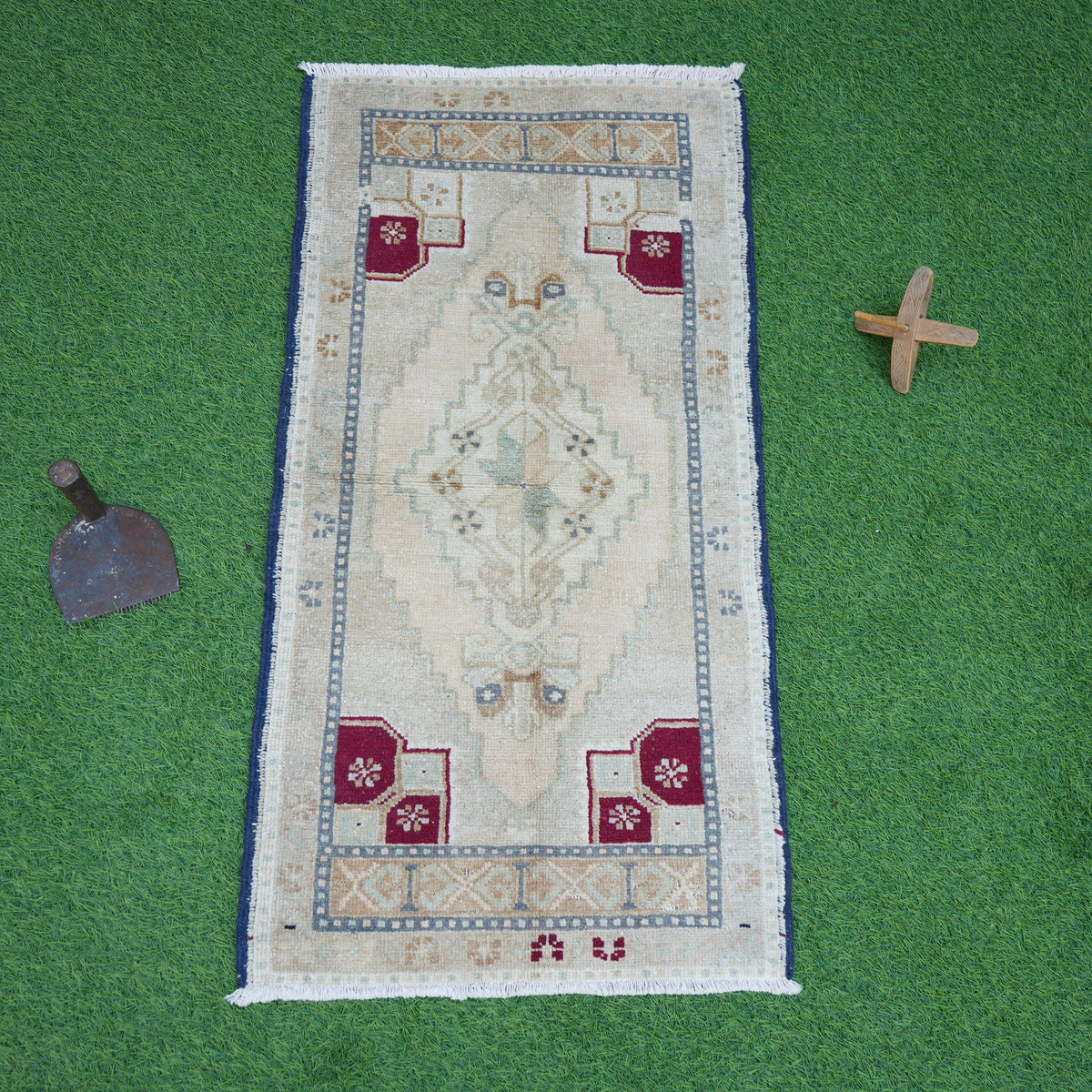 Close-up of the beige small turkish rug showing traditional details, hand-knotted weave, wool and cotton and low pile.