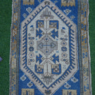 Close-up of the blue small turkish rug showing traditional details, hand-knotted weave, wool and low pile.