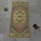 Pink 2' x 3' small turkish rug in wool and cotton, shown on the floor.