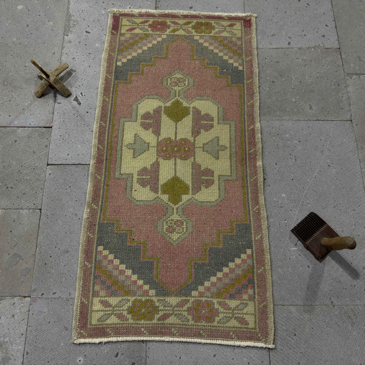 Pink 2' x 3' small turkish rug in wool and cotton, shown on the floor.