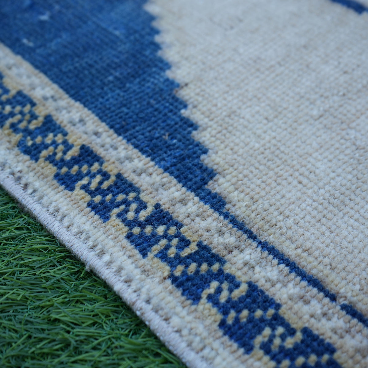 Blue 2' x 4' small turkish rug in wool, shown on the floor.