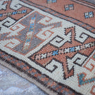 Pale Orange 3' x 4' small turkish rug in wool, shown on the floor.