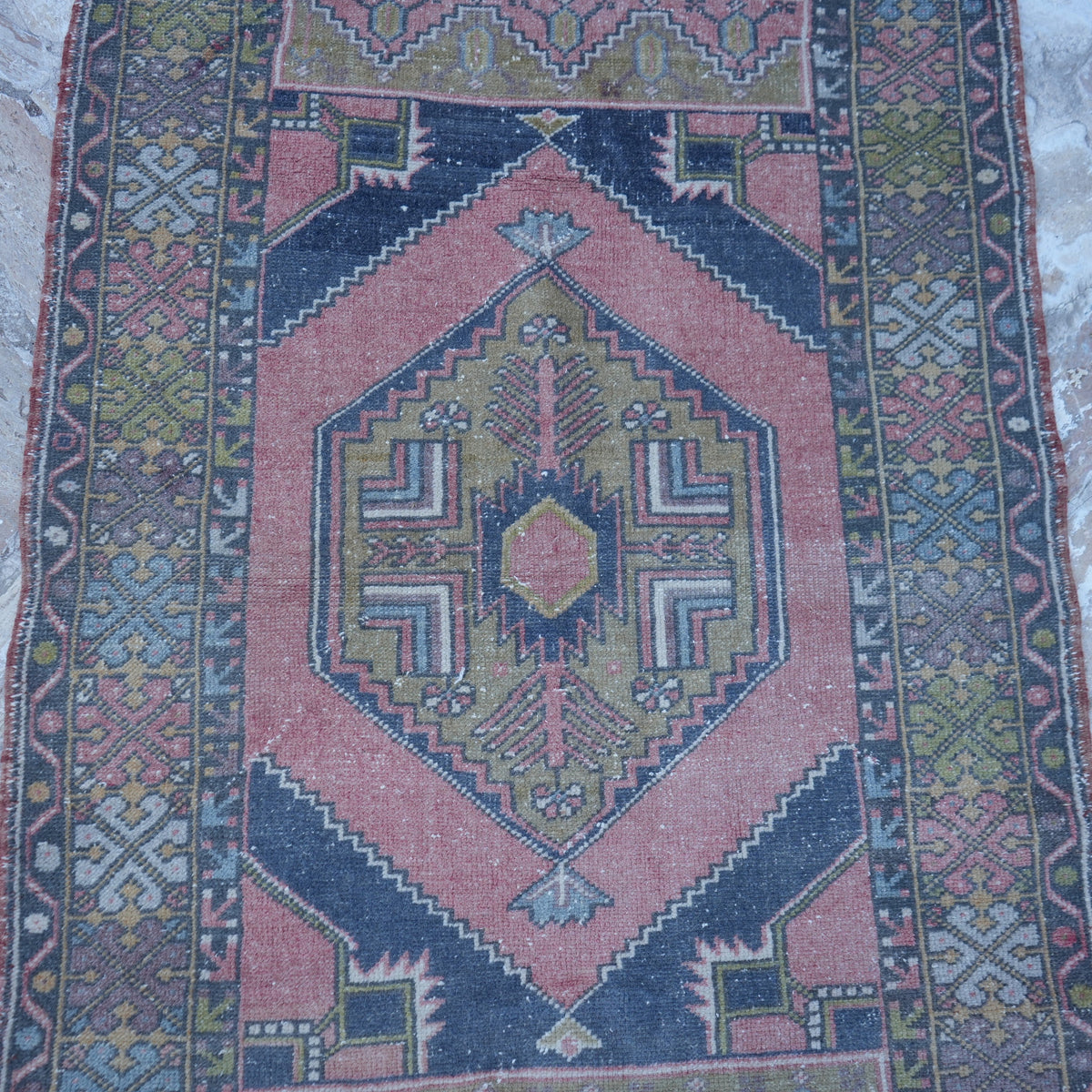 Close-up of the pink small turkish rug showing traditional details, hand-knotted weave, wool and low pile.