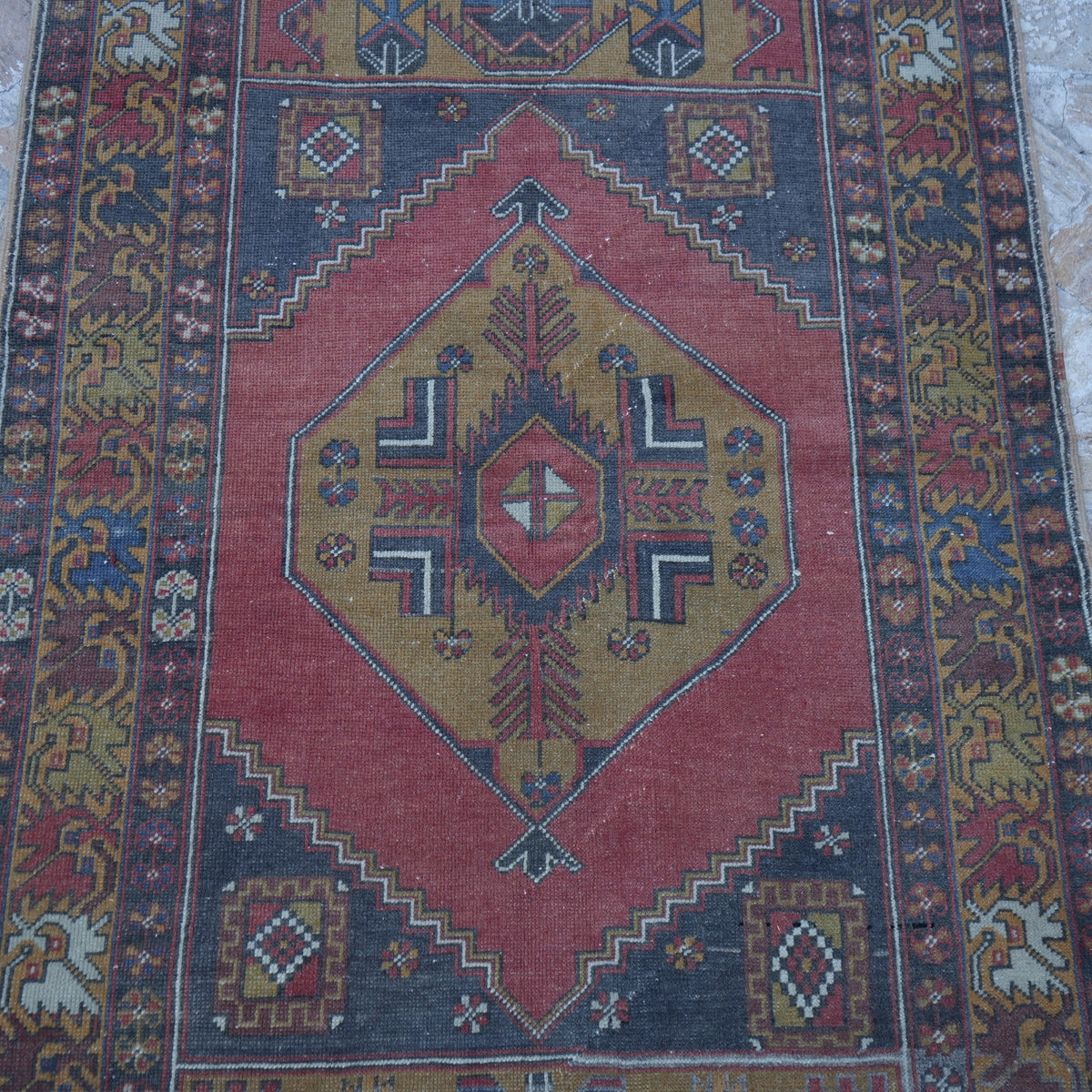 Close-up of the red small turkish rug showing traditional details, hand-knotted weave, wool and low pile.