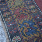 Red 4' x 6' small turkish rug in wool, shown on the floor.