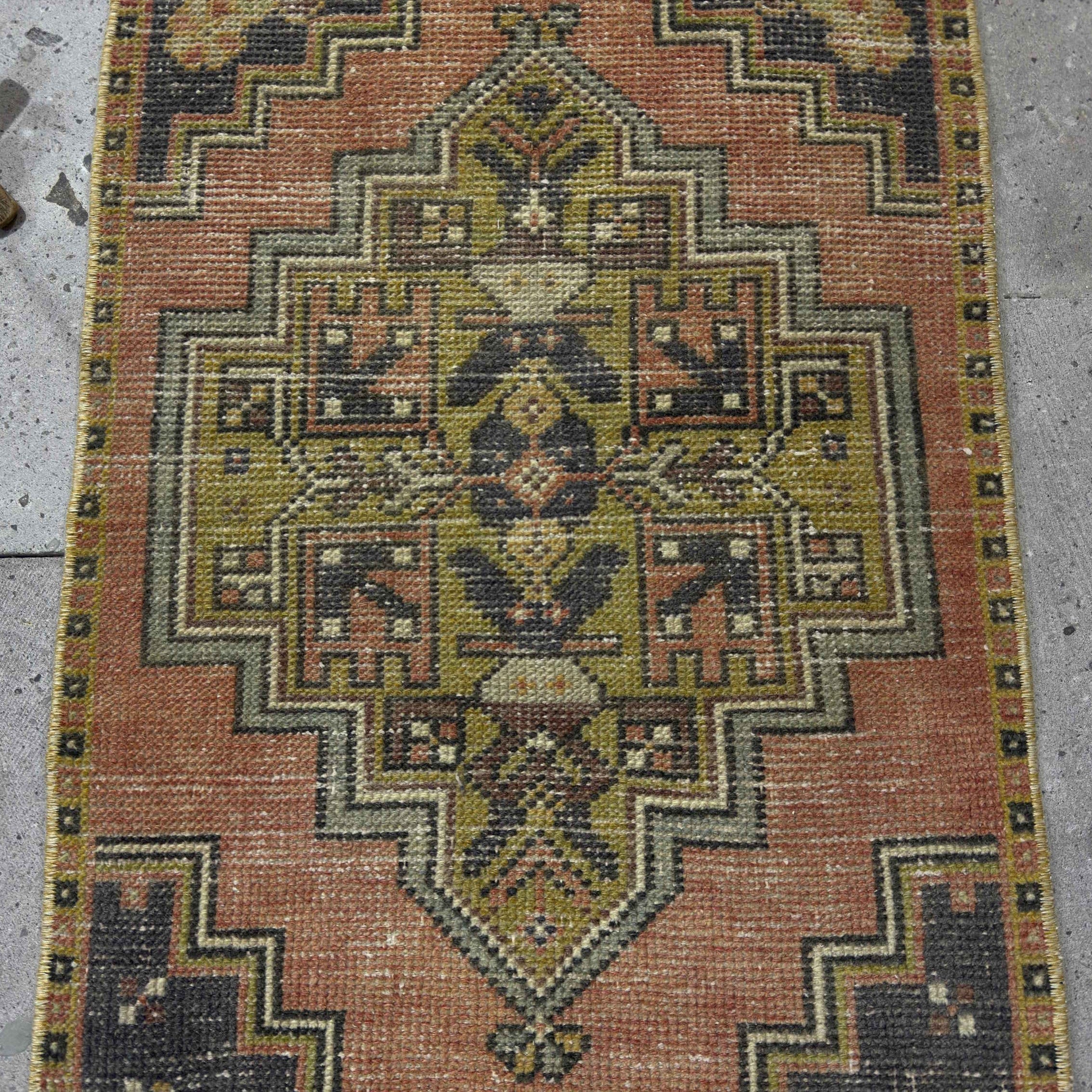 1970s pale red Turkish small vintage distressed rug with traditional design, hand-knotted weave and low pile.
