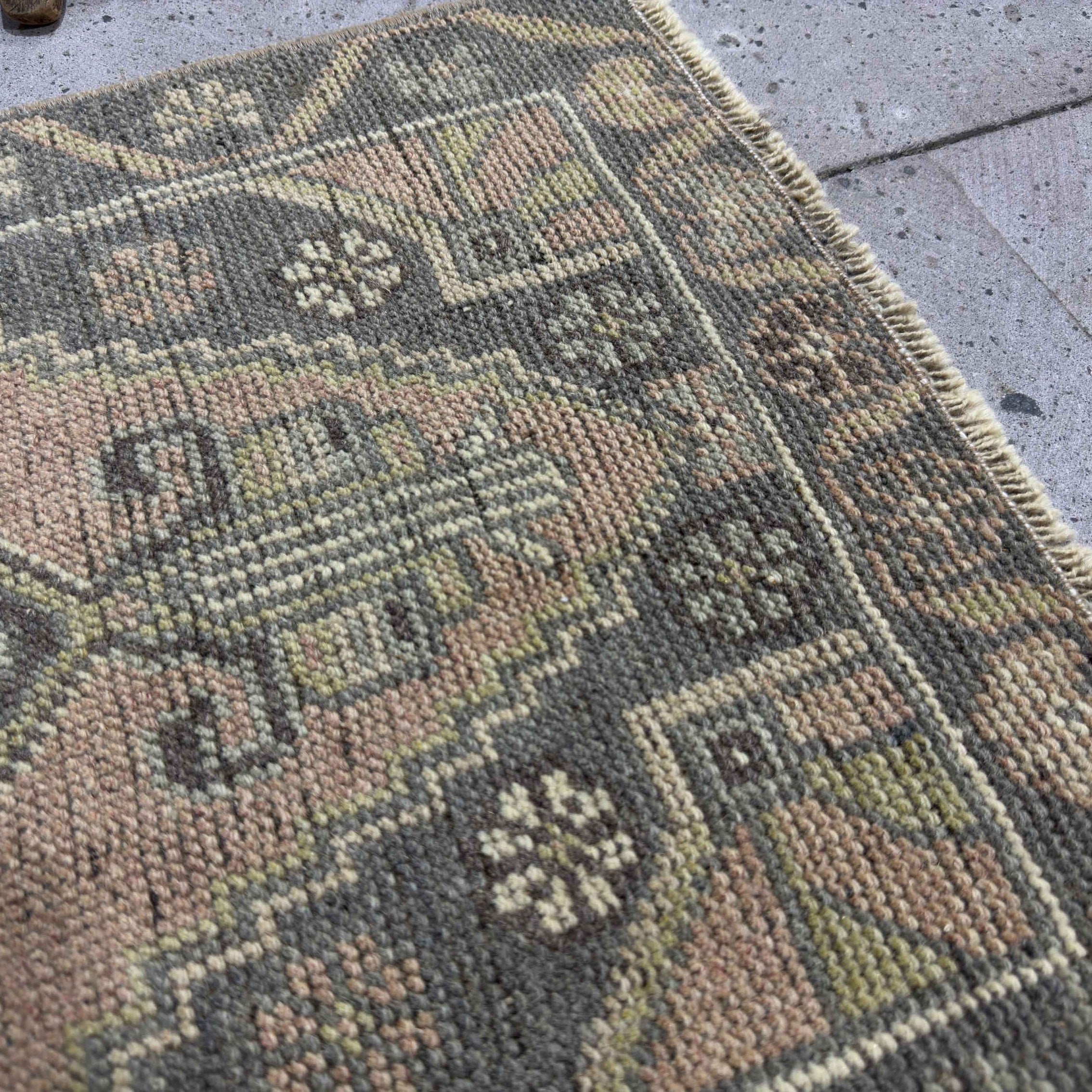 Close-up of the gray Turkish small vintage rug showing traditional details, hand-knotted weave, wool and cotton and low pile.