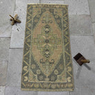 Gray 2' x 3' Turkish small vintage rug in wool and cotton, shown on the floor.