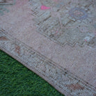 Pink 2' x 3' Turkish small vintage rug in wool and cotton, shown on the floor.