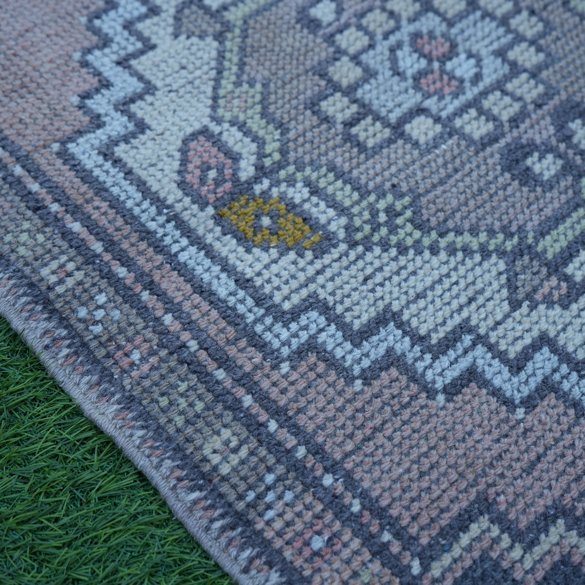 Pink 2' x 3' Turkish small vintage rug in wool and cotton, shown on the floor.