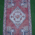 Close-up of the red Turkish small vintage rug showing traditional details, hand-knotted weave, wool and cotton and low pile.