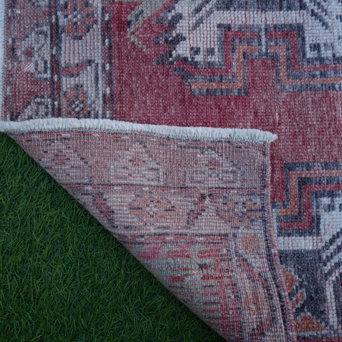 1970s red Turkish small vintage rug with traditional design, hand-knotted weave and low pile.
