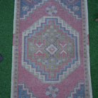 Close-up of the red Turkish small vintage rug showing traditional details, hand-knotted weave, wool and cotton and low pile.