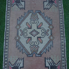 Close-up of the red Turkish small vintage rug showing traditional details, hand-knotted weave, wool and cotton and low pile.