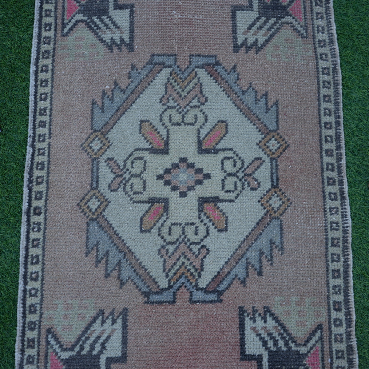 Close-up of the red Turkish small vintage rug showing traditional details, hand-knotted weave, wool and cotton and low pile.