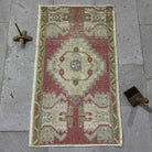 Red 2' x 3' Turkish small vintage rug in wool and cotton, shown on the floor.
