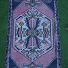 Close-up of the pink Turkish small vintage rug showing traditional details, hand-knotted weave, wool and cotton and low pile.