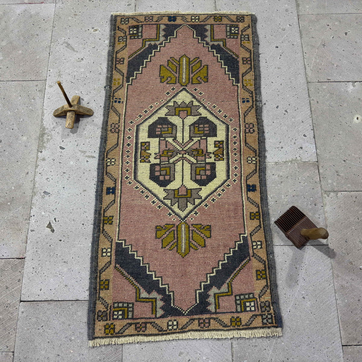 Pink 2' x 4' Turkish small vintage rug in wool and cotton, shown on the floor.