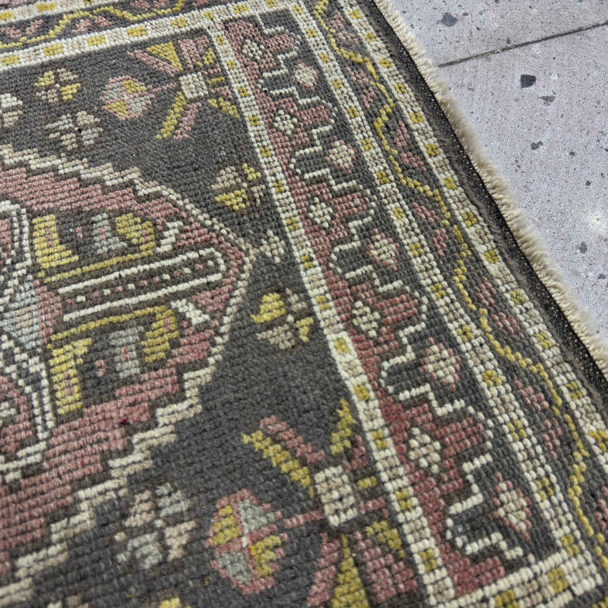 Close-up of the pink Turkish small vintage rug showing traditional details, hand-knotted weave, wool and cotton and low pile.