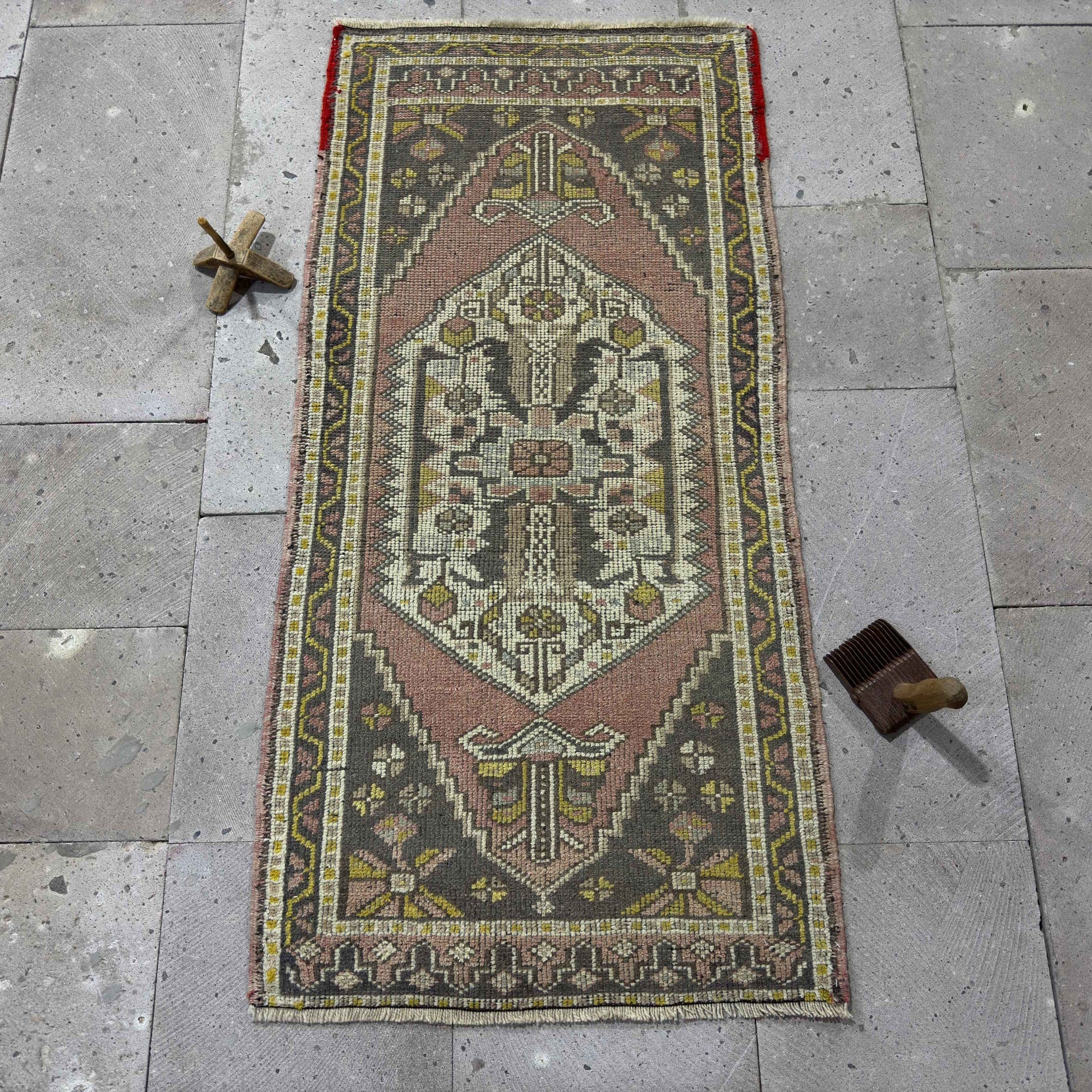 Pink 2' x 4' Turkish small vintage rug in wool and cotton, shown on the floor.