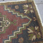 Close-up of the red Turkish small vintage rug showing traditional details, hand-knotted weave, wool and cotton and low pile.