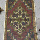 1970s red Turkish small vintage rug with traditional design, hand-knotted weave and low pile.