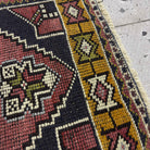Close-up of the red Turkish small vintage rug showing traditional details, hand-knotted weave, wool and cotton and low pile.