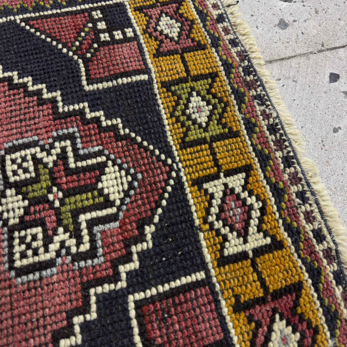 Close-up of the red Turkish small vintage rug showing traditional details, hand-knotted weave, wool and cotton and low pile.