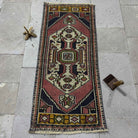 Red 2' x 4' Turkish small vintage rug in wool and cotton, shown on the floor.
